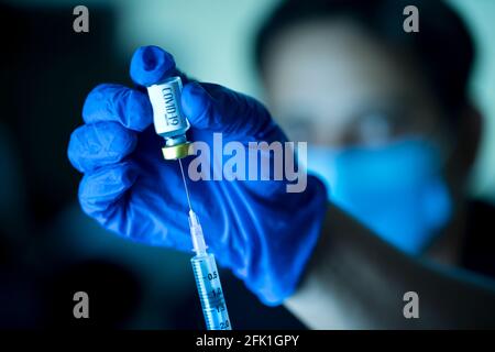 Arzt zieht Impfflüssigkeit aus dem Fläschchen, um den Mann zu impfen Stockfoto