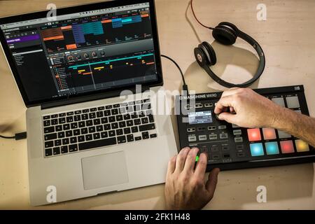 Elektronischer Musiker. Hände mit einem Maschine Midi Pad Controller mit einem MacBook Pro Stockfoto