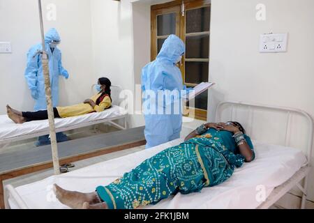 Gruppe von medizinischen Mitarbeitern besucht und untersucht indische Patienten bekommen Behandlung von Covid-19 Stockfoto