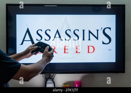 Mann, der den Dampfregler vor eine Bildschirmladung hält Ein Spiel von Assassinen Creed ein Action-Adventure-Spiel von ubisoft mit mehreren Installationen Stockfoto