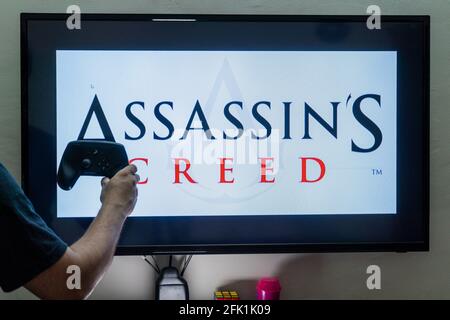 Mann, der den Dampfregler vor eine Bildschirmladung hält Ein Spiel von Assassinen Creed ein Action-Adventure-Spiel von ubisoft mit mehreren Installationen Stockfoto