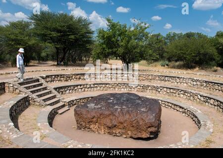 Eine Touristenfrau blickt auf den Hoba-Meteoriten, den größten bekannten Meteoriten der Erde, auf der Farm 'Hoba West' in der Nähe von Grootfontein, Namibia. Stockfoto