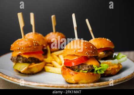 Mini-Burger und Bratkartoffeln auf dem Teller Stockfoto