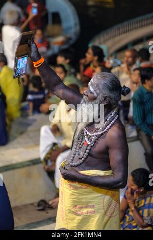 Varanasi, Indien - 2021. April: Pilger, der am 5. April 2021 in Indien das religiöse Ritual von Ganga Aarti auf dem Dashashwamedh Ghat mit seiner Tafel aufzeichnete. Stockfoto