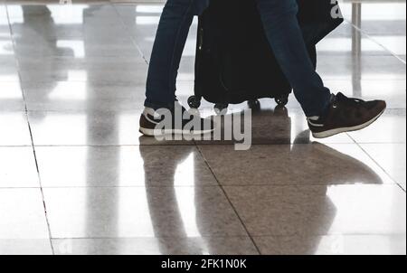 Reisende ziehen Koffer in modernen Flughafen Terminal. Reise und Verkehr Konzept Stockfoto