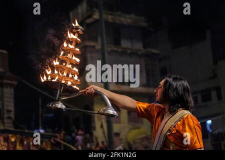 Varanasi, Indien - 2021. April: Hindu-Priester, der am 5. April 2021 in Indien das religiöse Ritual von Ganga Aarti im Dashashwamedh Ghat in Varanasi durchführt Stockfoto