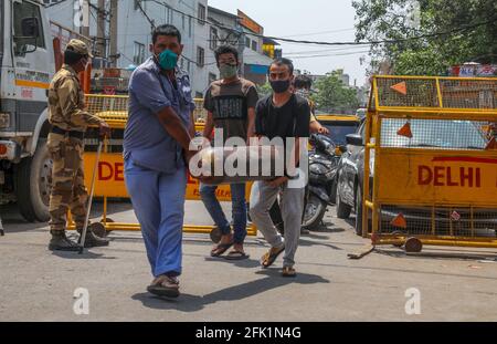 Neu-Delhi, Indien. April 2021. Familienmitglieder von Covid-19-infizierten Patienten tragen nachgefüllte Sauerstoffflaschen, da der Sauerstoffbedarf angesichts einer Zunahme der Coronavirus-Pandemie vor dem Sauerstoffnachfüllzentrum im Narayana Industrial Area in Neu-Delhi steigt. Den Krankenhäusern in Indien geht während der zweiten Welle der Covid-19-Pandemie die Sauerstoffversorgung für die Covid-19-Patienten aus. Kredit: SOPA Images Limited/Alamy Live Nachrichten Stockfoto