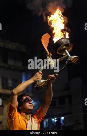 Varanasi, Indien - 2021. April: Hindu-Priester, der am 5. April 2021 in Indien das religiöse Ritual von Ganga Aarti im Dashashwamedh Ghat in Varanasi durchführt Stockfoto
