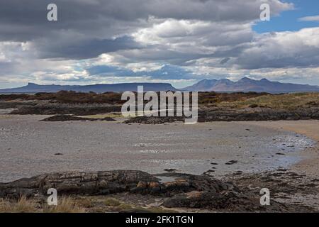 Lochaber, Schottland, UK Wetter. April 2021. Wolkiger und heller Nachmittag in Lochaber, immer noch recht ruhig auf den Straßen und schöne Strände mit gelegentlichen Campervan und Wohnmobil unterwegs. Abgebildet ist ein leerer Strand bei Traigh bei Arisaig mit Inseln im Hintergrund Stockfoto