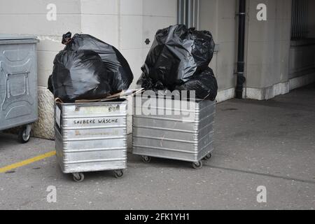 Abfallmanagement und zwei Bettlaken oder Trolleys mit großen schwarzen Plastiktüten im Hotelhinterhof. Stockfoto