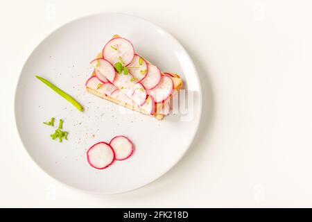 Gerösteter Toast mit frisch gehackten Radieschen und grünem Kraut auf dem weißen Teller. Gesundes Frühstück. Sandwich mit Gemüse. Stockfoto