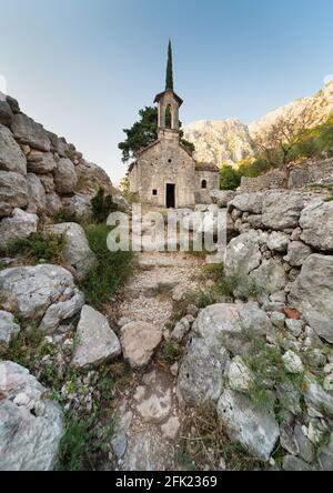 Neben der Festung von Kotor.die Ruinen umgeben diese kleine, stillvolle alte Kirche, inmitten wunderschöner Berglandslandschaften. Stockfoto