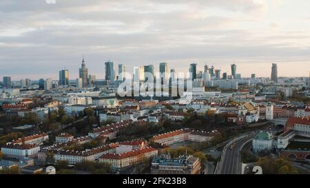 Luftaufnahme der Stadt Warschau, Hauptstadt von Polen. Wolkenkratzer und Bürogebäude vor dem wunderschönen, wolkenweißen Himmel. Fahrzeuge, die sich auf der Straße bewegen. Die Aufnahme wird am Morgen gemacht. Stockfoto