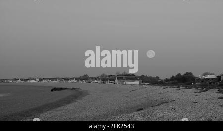 Vollmond am frühen Morgen im April vom Strand von Aldwick, West Sussex, England, Großbritannien aus gesehen. Stockfoto