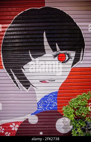 Coole Graffiti-Kunst des japanischen Mädchens mit Art-Deco-Haarschnitt und einem roten Auge. Anime-Porträt. Kunstwerke von Gassen in Kobe, Japan. Stockfoto