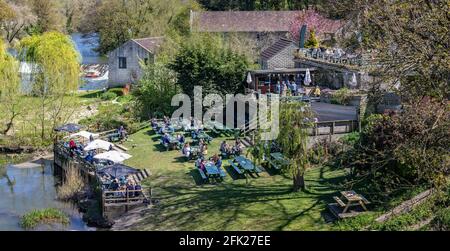 Menschen, die nach der Lockerung der Sperre am 25. April 2021 im Cross Guns Pub Garden in Avoncliff, Wiltshire, Großbritannien, gerne im Freien speisen Stockfoto