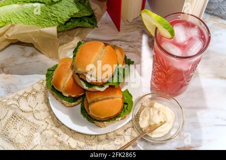Speisen im Freien knusprige Chicken Slider Sandwiches mit Literatur zur Unterhaltung Und Entspannung Stockfoto
