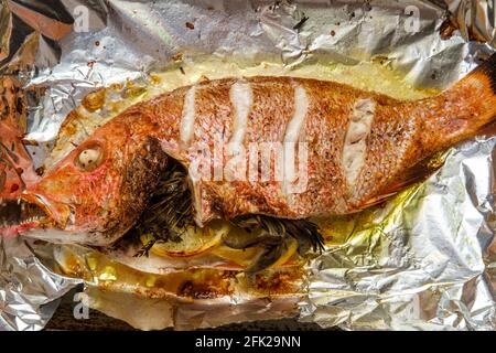 Im Ofen gebackenes Abendessen mit rotem Schnapper und Meeresfrüchten In Zinnfolie Stockfoto