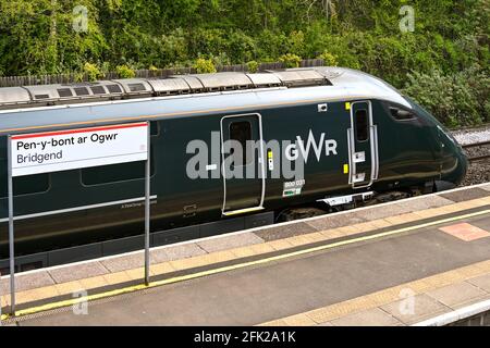 Bridgend, Wales - April 2021: Diesel-elektrischer Hochgeschwindigkeitszug der Klasse 800 am Bahnhof Bridgend hinter dem Bahnhofsschild. Stockfoto