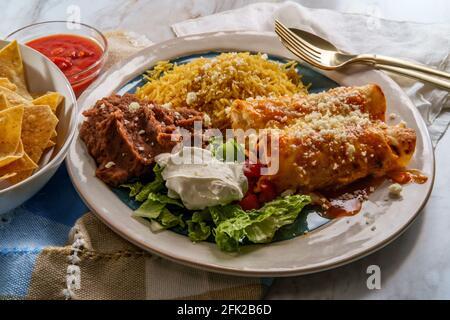 Traditionelles mexikanisches Enchiladas-Abendessen mit Reis und gebratenem Pinto Bohnen Stockfoto