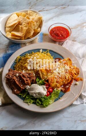 Traditionelles mexikanisches Enchiladas-Abendessen mit Reis und gebratenem Pinto Bohnen Stockfoto