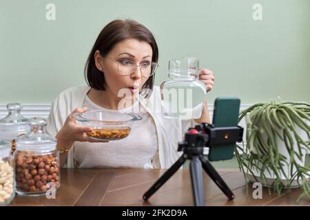 Ernährungswissenschaftler spricht über die Vorteile des Einweichens von Nüssen in Wasser, Aufnahme Video Blog vlog Stockfoto