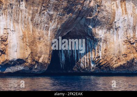 Blaues Meer und die charakteristischen Höhlen von Cala Luna, einem Strand im Golfo di Orosei, Sardinien, Italien. Große Meereshöhlen an der mittelmeerküste. Sardini Stockfoto