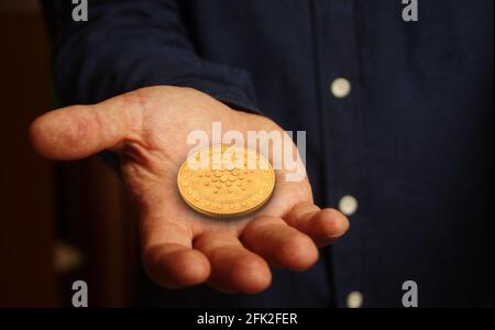 Cardano Ada Kryptowährung Symbol goldene Münze in der Hand abstraktes Konzept. Stockfoto