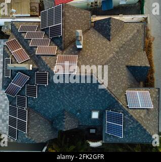 Luftaufnahme von Photovoltaik-Solarzellen auf einem eigenen Hausdach in einer kleinen europäischen Stadt. Konzept für erneuerbare grüne Energie Stockfoto