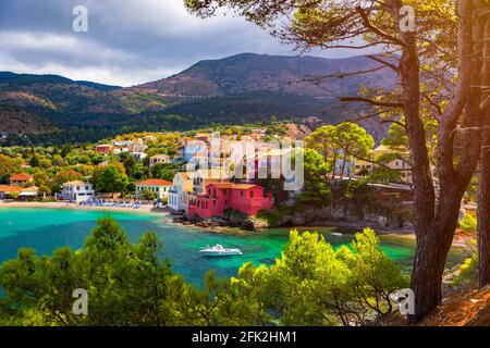 Türkisfarbene Bucht im Mittelmeer mit schönen bunten Häusern in Assos Dorf in Kefalonia, Griechenland. Stadt Assos mit bunten Häusern Stockfoto