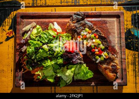 Chorizo/Churrasco-Steak mit kreolischer Sauce und Salat (typisch argentinische Küche). Stockfoto
