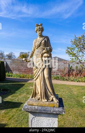 Statue einer griechischen Muse, wahrscheinlich Melpomene, in den Gärten von Dunsborough Park, Ripley, Surrey, Südostengland im April Stockfoto