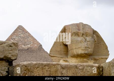 Kopf der ikonischen Monumentalskulptur, der Großen Sphinx von Gizeh mit der Pyramide von Khepre dahinter, Gizeh Plateau, Kairo, Ägypten Stockfoto