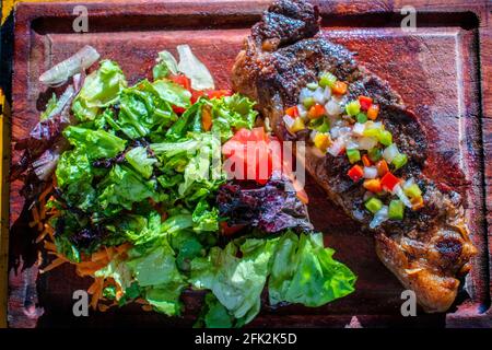 Chorizo/Churrasco-Steak mit kreolischer Sauce und Salat (typisch argentinische Küche). Stockfoto