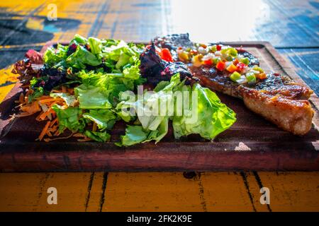 Chorizo/Churrasco-Steak mit kreolischer Sauce und Salat (typisch argentinische Küche). Stockfoto