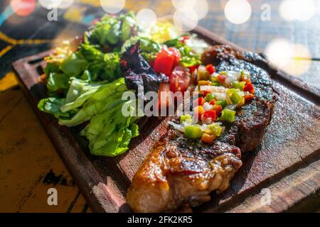 Chorizo/Churrasco-Steak mit kreolischer Sauce und Salat (typisch argentinische Küche). Stockfoto