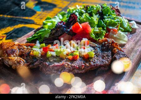 Chorizo/Churrasco-Steak mit kreolischer Sauce und Salat (typisch argentinische Küche). Stockfoto