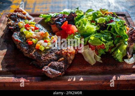 Chorizo/Churrasco-Steak mit kreolischer Sauce und Salat (typisch argentinische Küche). Stockfoto