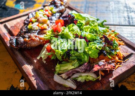 Chorizo/Churrasco-Steak mit kreolischer Sauce und Salat (typisch argentinische Küche). Stockfoto