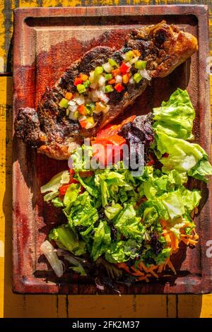 Chorizo/Churrasco-Steak mit kreolischer Sauce und Salat (typisch argentinische Küche). Stockfoto