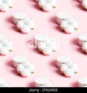 Weiße, trockene Baumwollblumen und nahtlose Muster auf hellrosa Hintergrund. Stockfoto