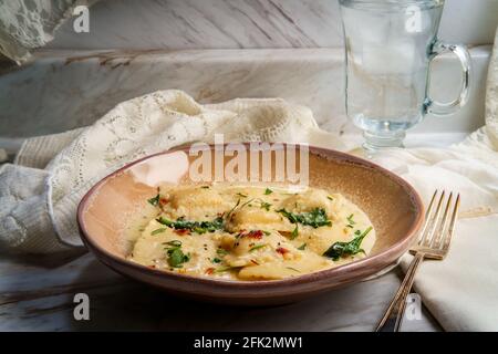 Käseravioli in einer toskanischen cremigen Sauce mit Spinat und Zerkleinerte rote Paprika Stockfoto