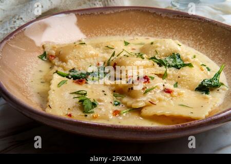 Käseravioli in einer toskanischen cremigen Sauce mit Spinat und Zerkleinerte rote Paprika Stockfoto