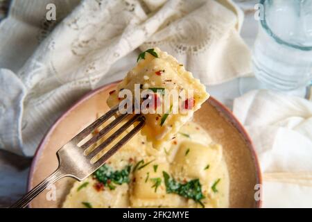 Käseravioli in einer toskanischen cremigen Sauce mit Spinat und Zerkleinerte rote Paprika Stockfoto