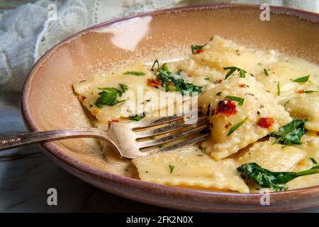 Käseravioli in einer toskanischen cremigen Sauce mit Spinat und Zerkleinerte rote Paprika Stockfoto