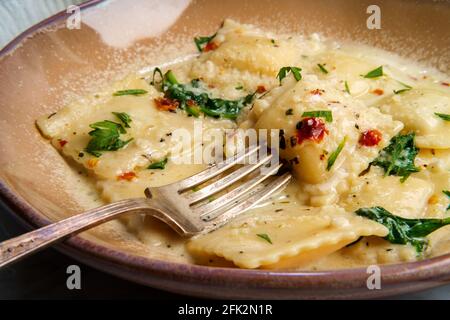 Käseravioli in einer toskanischen cremigen Sauce mit Spinat und Zerkleinerte rote Paprika Stockfoto