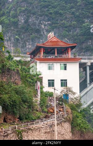 Wushan, Chongqing, China - 7. Mai 2010: Wu-Schlucht im Yangtze-Fluss. Nahaufnahme des weißen Hotel-Restaurants mit rotem Chinse-Dach, auf Stelzen gebaut Stockfoto