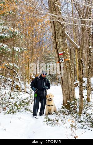 Mann beim Wandern mit seinem Hund im Winter. Stockfoto