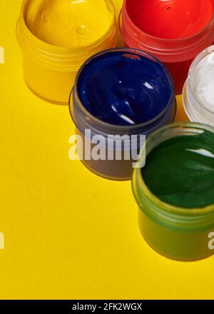 Bunte Farbdosen auf gelbem Hintergrund Stockfoto