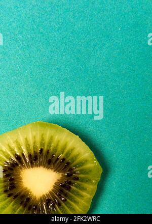 Kiwi-Scheibe auf blauem Hintergrund liegt Stockfoto